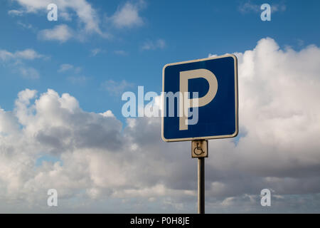 Traffico segno di parcheggio per disabili. Intensa nuvole bianche su un cielo blu dopo una notte di pioggia. Foto Stock