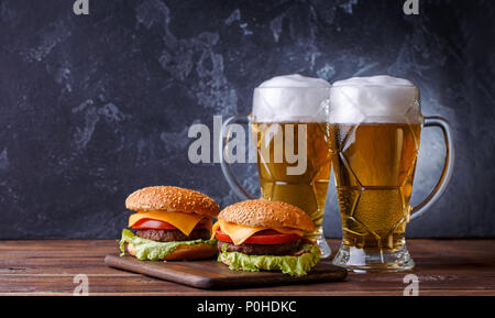 Foto di due hamburger, bicchieri di birra Foto Stock