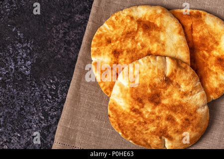 Pane Pita al buio su un tavolo, vista dall'alto, copia dello spazio. Foto Stock