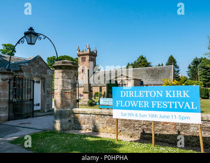 Dirleton Village Gardens, Scotland’s Gardens Scheme 2018, 9 giugno 2018. Dirleton Village, East Lothian, Scozia, Regno Unito. I residenti del villaggio aprono i loro giardini al pubblico come parte del programma giardini nazionali. Il Dirleton Kirk Flower Festival si svolge anche durante il fine settimana a Dirleton Kirk. Il cancello d'ingresso ornato della chiesa con lampada vecchio stile e segno del festival in una giornata di sole con cielo blu Foto Stock