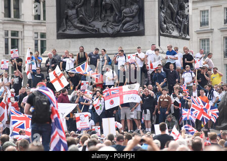 La Difesa inglese League e altri sostenitori radunati in Trafalgar Square per una manifestazione di protesta contro l'arresto di Tommy Robinson. In piedi intorno all ombra della Colonna di Nelson. Foto Stock