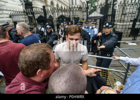 Londra, Regno Unito. Il 9 giugno 2018. Uno steward sostiene con manifestanti a Downing St chiedendo loro di spostare twards il palcoscenico per il rally che sta per iniziare. La folla si era radunata davanti a Downing Street e due teppisti ha tentato di afferrare me e tirare la mia fotocamera dalla mia mano per evitare che mi fotografare. Sono riuscito a tirare fuori e passare attraverso la densa folla, ma essi mi ha seguito attraverso la massa di persone per una certa distanza tentare ripetutamente di prendere il mio telecamere ed borsa fino a quando mi sono avvicinato alla polizia e MARZO STEWARD davanti a Downing St. Credito: Peter Marshall / Alamy Live News Credit: Pet Foto Stock