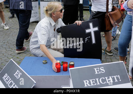 Mainz, Germania. Il 9 giugno 2018. Una donna mette una candela su un make-shift santuario. Il gruppo parlamentare del Landtag (parlamento) della Renania Palatinato del diritto-ala partito AfD (alternativa per la Germania) ha organizzato una veglia al di fuori della Renania Palatinato Cancelleria di Stato in Mainz per l'adolescente Susanna F., che è stato ucciso da un richiedente asilo. Essi hanno anche chiamato per entrambi di dimettersi. Credito: Michael Debets/Alamy Live News Credito: Michael Debets/Alamy Live News Foto Stock