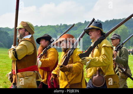 Piccolo gruppo del xvii secolo moschettieri in buff cappotti marciando con moschetti sulla spalla, guerra civile inglese, 1641 a 1652 Foto Stock