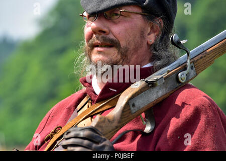 Ritratto del xvii secolo musketeer in costume con moschetto sulla spalla nella guerra civile inglese rievocazione Foto Stock