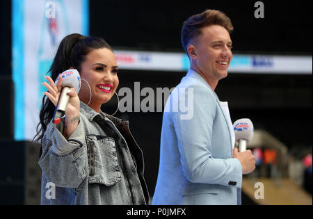 Demi Lovato e Roman Kemp sul palco durante la capitale estiva della sfera con Vodafone presso lo Stadio di Wembley a Londra. Foto Stock