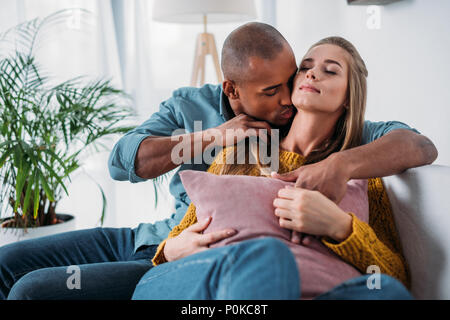 African American fidanzato bacio fidanzate collo Foto Stock