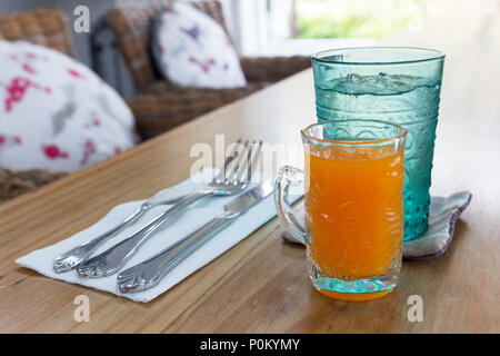 Acqua pura e succo di arancia sul tavolo di legno, il momento della colazione. Foto Stock