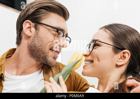 Close-up shot di felice giovane uomo presentando tulip fiore alla ragazza Foto Stock