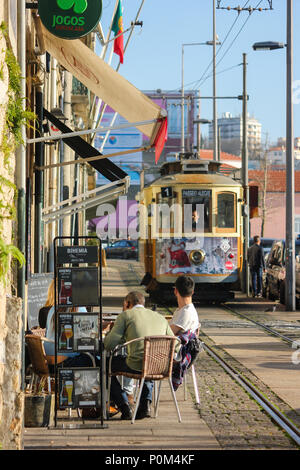 Persone da pranzo i binari del tram in una giornata di sole a Porto, Portogallo Foto Stock