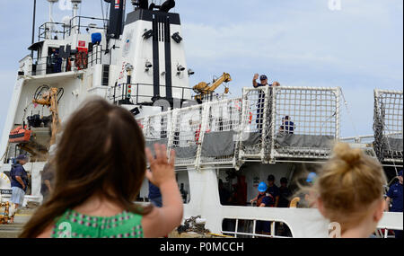 Una giovane ragazza onde da suo padre il guardacoste decisivi in quanto la taglierina si prepara a moor.La mossa decisiva da Pascagoula, Mississippi, al suo nuovo homeport in Pensacola, Florida, Giugno 5, 2018. Stati Uniti Coast Guard foto di Sottufficiali di terza classe Lora Ratliff Foto Stock