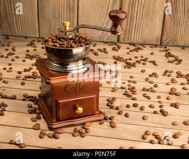 Foto di vintage caffè macinacaffè su sfondo legno sfondo. Foto Stock