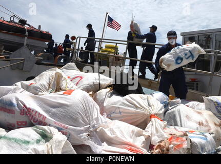 L'equipaggio del guardacoste Thetis offload circa 2,116 libbre di marijuana dopo il ritorno a homeport di Key West, Florida, Venerdì, Giugno 8, 2018. In marzo, Thetis il suo equipaggio a fianco di un MH-65 Delfino elicottero equipaggio dalla stazione aria Borinquen, Puerto Rico e un giamaicano Defence Force equipaggio interdetto un sospetto di contrabbando di droga peschereccio nei Caraibi. (U.S. Coast Guard foto di Sottufficiali di seconda classe Ashley J. Johnson) Foto Stock