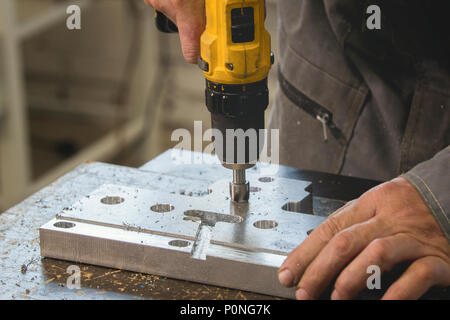 Maschio mani di lavoro industriale di foratura oggetto di metallo Foto Stock