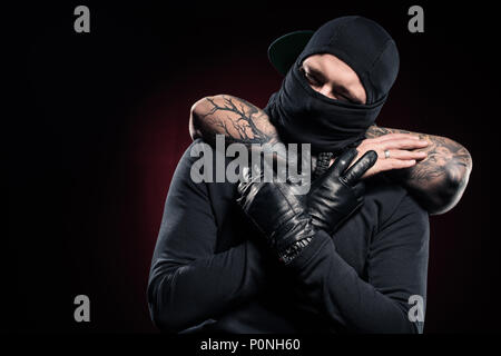 L'uomo soffoca ladro vestito in abiti neri e passamontagna Foto Stock