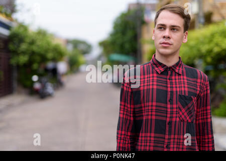 Giovane uomo bello indossare rosso a scacchi shirt nelle strade ou Foto Stock