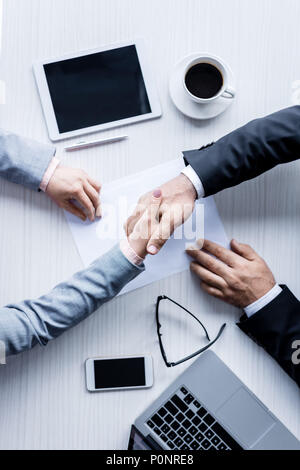 Vista superiore della gente di affari si stringono la mano durante la riunione Foto Stock