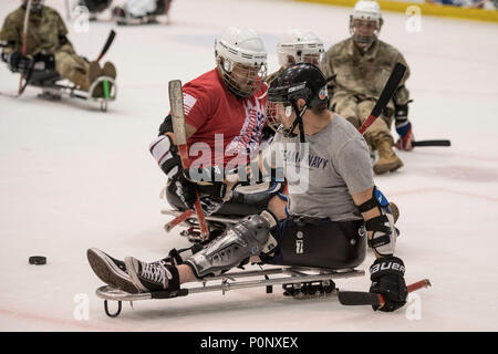 Il veterano della marina Sottufficiali di terza classe Doug Hill, a sinistra, e il veterano della Marina Militare marinaio campo la possibilità di partecipare a un gioco di prelievo di hockey su slitta durante il 2018 DoD Warrior giochi presso l'U.S. Air Force Academy in Colorado Springs il 7 giugno 2018. Il guerriero i giochi sono un evento annuale, istituito nel 2010, per introdurre feriti e ammalati e feriti i membri del servizio di adaptive lo sport come un modo per migliorare il loro recupero e riabilitazione. (DoD Foto di Roger L. Wollenberg) Foto Stock