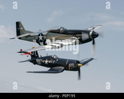 Un North American P Mustang e un Vought F4U Corsair volare come parte di un patrimonio di volo in sostegno della Air Force Reserve settimana, Niagara Falls, N.Y., Giugno 7, 2018. I due piani, risalente alla II Guerra Mondiale, entrato a far parte di un Douglas C-47 Skytrain e un Boeing B-17 Flying Fortress per celebrare il settantesimo compleanno della Air Force Reserve. (U.S. Air National Guard dal personale Sgt. Ryan Campbell) Foto Stock