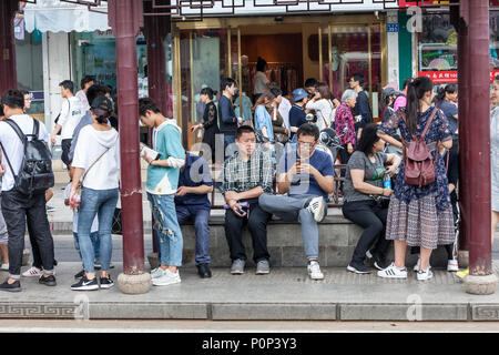 Suzhou, Jiangsu, Cina. Il cinese alla fermata dell autobus. Foto Stock