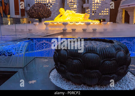 Nanjing, Jiangsu, Cina. Scultura di Buddha in Usnisa Palace, Niushou Montagna. Lotus scultura in primo piano. Foto Stock