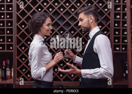 Due sommeliers, maschio e femmina rosso di degustazione vino in cantina Foto Stock