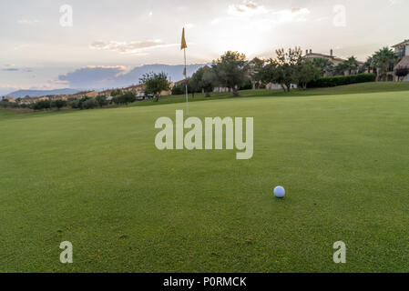 Palla da golf sul green fairway nuvoloso blu cielo estate in background Foto Stock