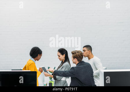 Giovani multietnica business partner che lavorano insieme in un ufficio moderno Foto Stock