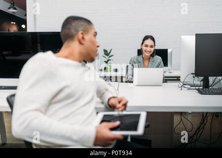 Multietnica young business partner parlando in ufficio Foto Stock