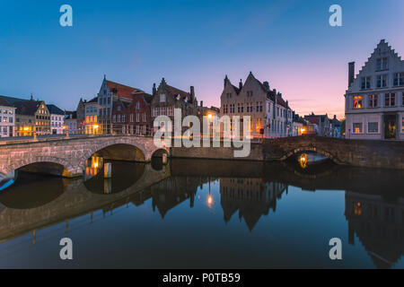 Le luci del tramonto su edifici storici del centro città si riflette nei tipici canali di Bruges Fiandre Occidentali Foto Stock