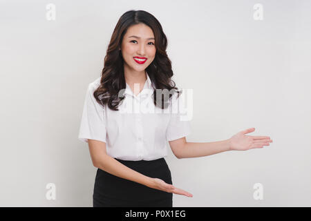 Business donna asiatica facendo gesto di benvenuto su sfondo bianco Foto Stock