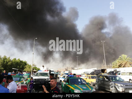 Baghdad in Iraq. Decimo Giugno, 2018. Il fumo è visto presso il sito dove un enorme incendio scoppiato in tre magazzini contenenti urne dell'Iraq elezioni parlamentari nel centro cittadino di capitale Baghdad, Iraq, 10 giugno 2018. Credito: Khalil Dawood/Xinhua/Alamy Live News Foto Stock