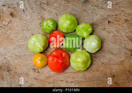 Peperoni freschi cachucha, vivaci e pronti per avventure culinarie, disposti ordinatamente su un tavolo rustico. Foto Stock