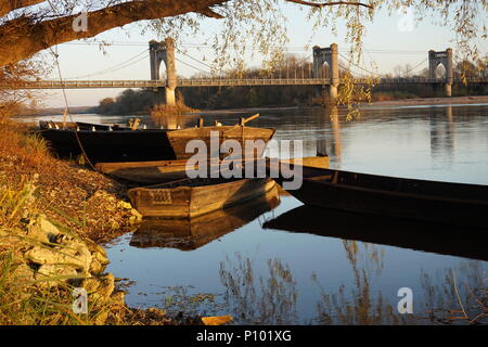 Specchio di riflessione il vecchio ponte in pietra e tipiche imbarcazioni in legno del fiume Loira in Langeais, Francia Foto Stock