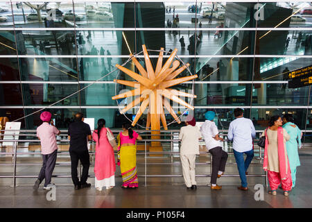 NEW DELHI, India - circa aprile 2017: persone sostare di fronte alla più grande del mondo charkha (ruota di filatura) presso l'Aeroporto Internazionale Indira Gandhi e. Foto Stock