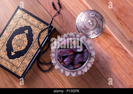 Date con rosario e santo Corano su sfondo di legno vista dall'alto.-Ramadan kareem/l'Eid Al Fitr Concept Foto Stock