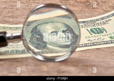 Centinaia di dollari sotto una lente di ingrandimento. CLose up. Dollari USA schiarire sotto la lente di ingrandimento l'esame. Foto Stock