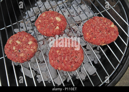 Pericolo di intossicazione alimentare da estate barbecue di carne e salumi, hamburger, spiedini, sotto-cotto o crudo Foto Stock