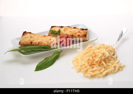 Formaggio grattugiato accanto a una piastra con due panini di formaggio Foto Stock