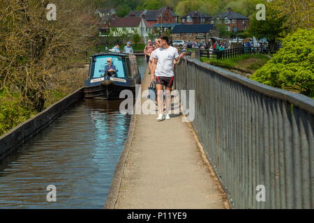 Guardando verso il bacino Trefor come una barca stretta passa la gente sulla strada alzaia dell'Acquedotto Pontcysyllte Foto Stock