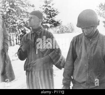 Tahae Sugita (a destra), un soldato Japanese-American con il campo 522nd battaglione di artiglieria, sorge accanto a un campo di concentramento superstite ha appena liberato su una morte marzo da Dachau nel maggio 1945. Foto Stock