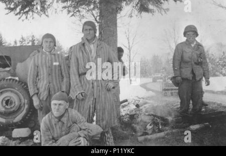 George Oiye (a destra), un soldato Japanese-American con il campo 522nd battaglione di artiglieria, prepara un fuoco di campo per campo di concentramento i prigionieri liberati dalla sua unità vicino la città di Waakirchen nel maggio 1945. Foto Stock