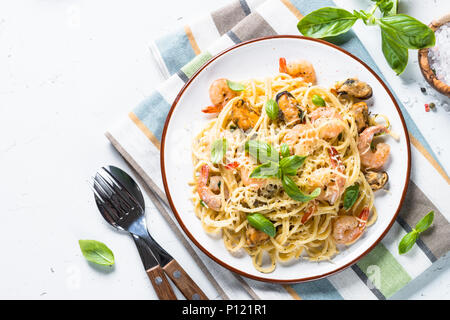 Pasta spaghetti con frutti di mare e salsa alla panna su bianco. Foto Stock