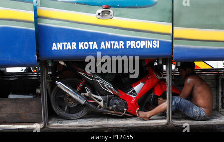 West Java, Indonesia. Il 9 giugno 2018. Bus di equipaggio solleva moto a tetto autobus presso la piscina di Croce Intercity (Antar Lintas Sumatra) ALS, Bogor, West Java, Indonesia. Verso l'Eid al-Fitr, musulmani indonesiani eseguire la tradizione di 'Mudik' viaggio verso il villaggio di soddisfare con la famiglia. ( Foto di Adriana Adinandra/Pacific Stampa) Credito: PACIFIC PRESS/Alamy Live News Foto Stock