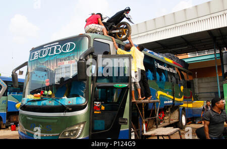 West Java, Indonesia. Il 9 giugno 2018. Bus di equipaggio solleva moto a tetto autobus presso la piscina di Croce Intercity (Antar Lintas Sumatra) ALS, Bogor, West Java, Indonesia. Verso l'Eid al-Fitr, musulmani indonesiani eseguire la tradizione di 'Mudik' viaggio verso il villaggio di soddisfare con la famiglia. ( Foto di Adriana Adinandra/Pacific Stampa) Credito: PACIFIC PRESS/Alamy Live News Foto Stock