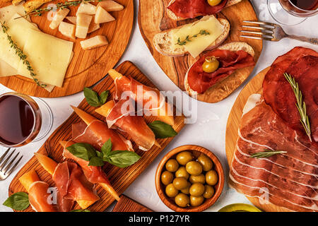 Il cibo italiano sfondo con prosciutto e formaggio, olive, pane e vino. Foto Stock