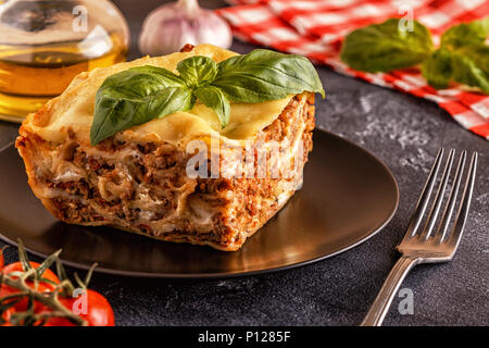 Lasagne tradizionali realizzati con le carni bovine macinate ragù alla bolognese e besciamella guarnita con foglie di basilico. Foto Stock