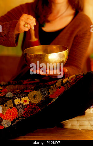 Ragazza spirituale immerso in suoni meditativa della ciotola tibetian. Foto Stock