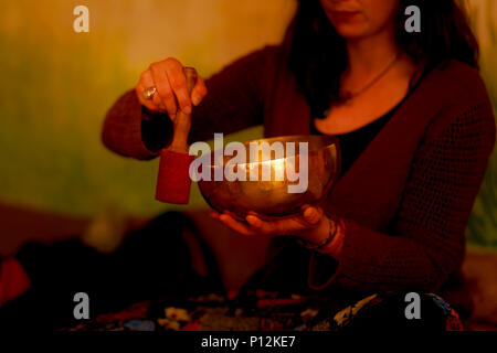 Ragazza spirituale immerso in suoni meditativa della ciotola tibetian. Foto Stock