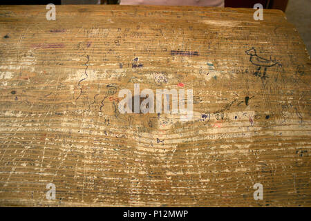 Gli scarabocchi su una vecchia scrivania in legno a scuola in Romania Foto Stock